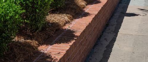 brick retaining wall next to a side walk